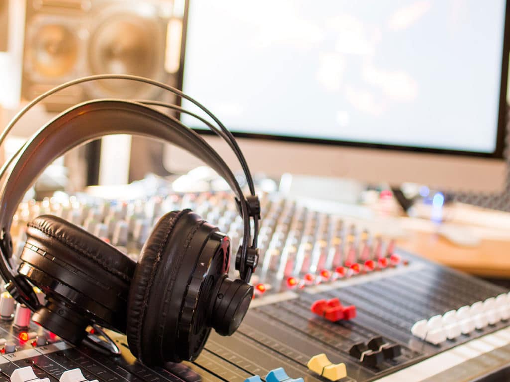 A pair of headphones on a mixing board.